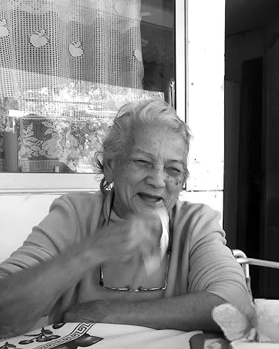 Doña Juanita, Juana Molina, sonriendo sentada a la mesa de su casa