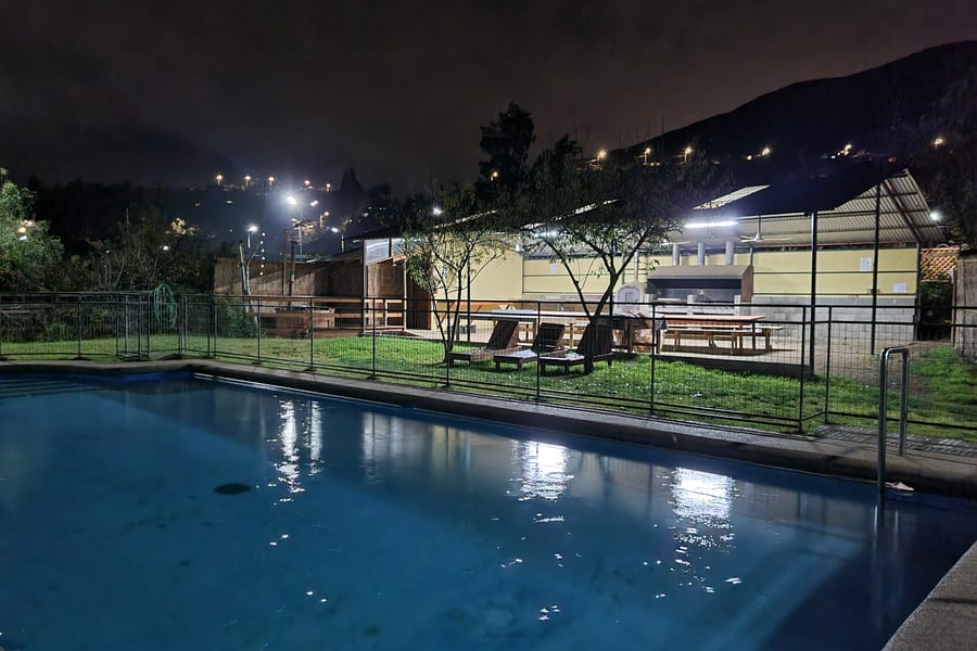 La piscina con las reposeras y los cerros al fondo